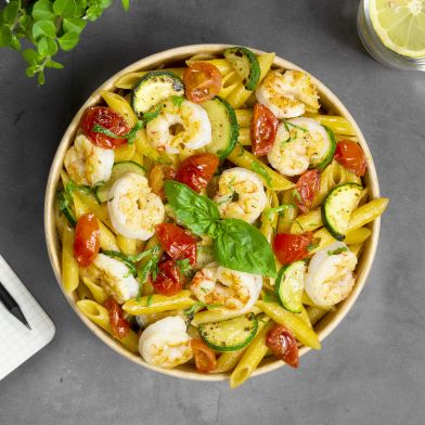 Pennette con gamberoni sfumati al brandy, zucchine e pomodorini spadellati